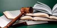 Close up of a brown wooden gavel and book